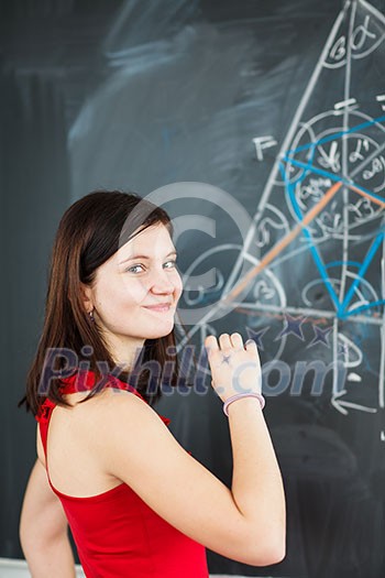 Portrait of a pretty young college student writing on the blackboard during a maths class (color toned image) Portrait of a pretty young college student writing on the blackboard during a maths class (color toned image)