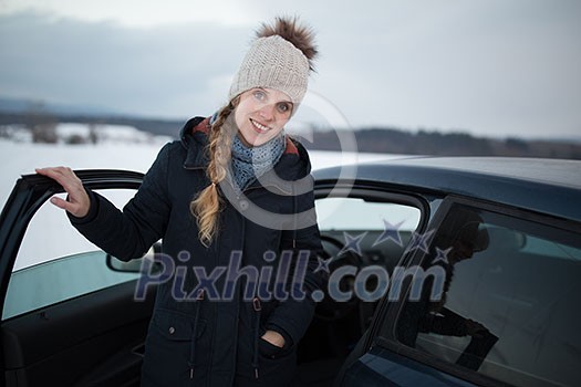 Woman driving a car - female driver at a wheel of a modern car, looking happy, smiling with a relaxed smile (shallow DOF; color toned image) Woman driving a car - female driver at a wheel of a modern car, looking happy, smiling with a relaxed smile (shallow DOF; color toned image)