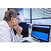 Senior male researcher carrying out scientific research in a lab (shallow DOF; color toned image)