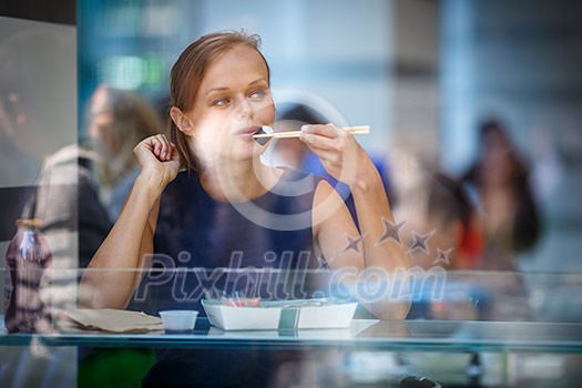 Pretty, young woman eating sushi in a restaurant, having her lunch break, enjoying the food, pausing for a while from her busy corporate/office life (color toned image) Pretty, young woman eating sushi in a restaurant, having her lunch break, enjoying the food, pausing for a while from her busy corporate/office life (color toned image)