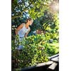 Pretty, young woman gardening in her garden, cutting branches, preparing the orchard for the winter