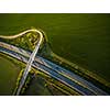 Aerial view of a highway amid fields with cars on it