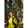 Pretty, young female hiker walking through a splendid old pine forest (shallow DOF)