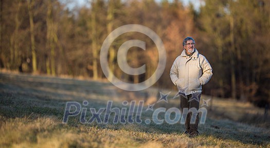 Portrait of a senior man relaxing during a walk outdoors, on a sunny winter day Portrait of a senior man relaxing during a walk outdoors, on a sunny winter day