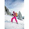 Pretty, young woman snowshoeing in high mountains, enjoying splendid winter weather with abundance of snow