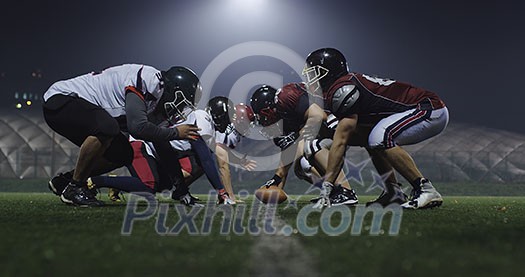 american football players are ready to start on field at night american football players are ready to start on field at night