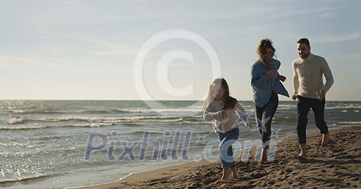 Family with kids resting and having fun at beach during autumn day Family with kids resting and having fun at beach during autumn day