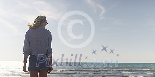 Young woman on the beach. The girl enjoying the warm autumn day. Portrait of beautiful girl near the water Young woman on the beach. The girl enjoying the warm autumn day. Portrait of beautiful girl near the water