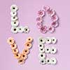 The word love is made of, white, pink and orange gerbera flowers on a pink background. As a greeting card for Valentine's Day or Mother's Day . Flat lay.
