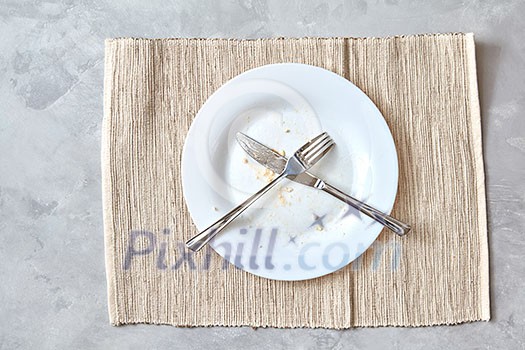 Metal fork and knife on a stone table. arrangement of cutlery after meals, end-of-meal sign. Photo from a series of step-by-step cooking and serving salad. Top view, flat lay. Metal fork and knife on a stone table. arrangement of cutlery after meals, end-of-meal sign. Photo from a series of step-by-step cooking and serving salad. Top view, flat lay.