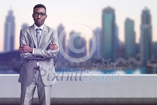 Portrait of young black businessman standing on balcony in front of the big city Portrait of young black businessman standing on balcony in front of the big city