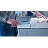 assistant makes copies of files in the copy machine