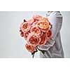 Girl with a bouquet of beautiful pink media roses on a gray background. Mother's Day, Valentine's Day