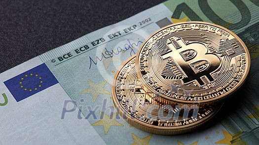 Two gold coins bitcoin stack on paper euro bill. Investing in crypto currency. Exchange bitcoin cash for a dollar. Two gold coins bitcoin stack on paper euro bill. Investing in crypto currency. Exchange bitcoin cash for a dollar.