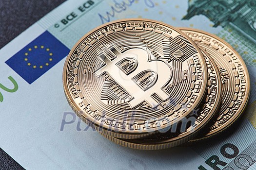 Stack of gold coins bitcoin stack on a euro bill. Digital coin money and digital payment system. Investing in crypto currency. Stack of gold coins bitcoin stack on a euro bill. Digital coin money and digital payment system. Investing in crypto currency.