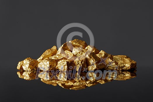 Close up of mound of gold nuggets on a black reflective surface background. Concept of financing and Noble metal Close up of mound of gold nuggets on a black reflective surface background. Concept of financing and Noble metal