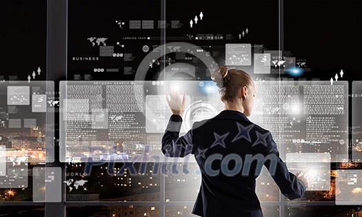 Rear view of businesswoman touching icon of media screen Rear view of businesswoman touching icon of media screen