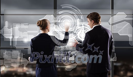 Rear view of businessman and businesswoman touching icon of digital screen Rear view of businessman and businesswoman touching icon of digital screen