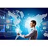 Young businessman with tablet in hands against digital background