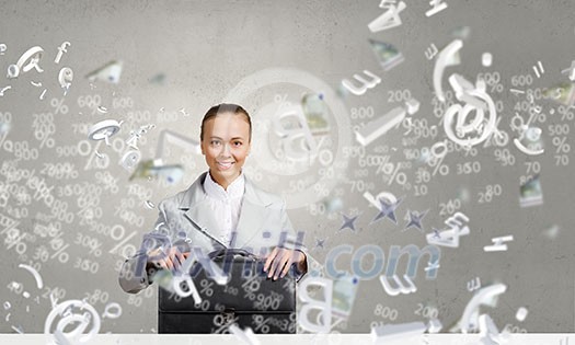 Young pretty businesswoman sitting with briefcase in hands Young pretty businesswoman sitting with briefcase in hands