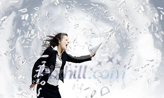 Young determined businesswoman walking against strong wind Young determined businesswoman walking against strong wind