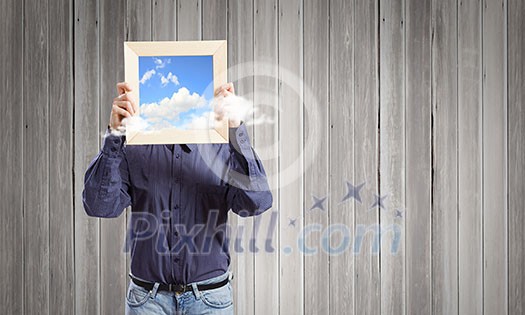 Young woman in shirt with wooden frame in hands Young woman in shirt with wooden frame in hands