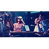 Multiethnic Business team using virtual reality headset in night office meeting  Developers meeting with virtual reality simulator around table in creative office.