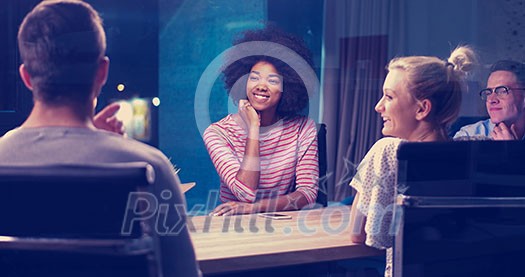 Multiethnic startup business team on meeting in modern night office interior brainstorming, working on laptop Multiethnic startup business team on meeting in modern night office interior brainstorming, working on laptop