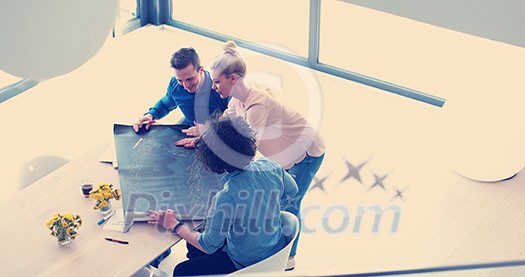 Group of a young business people discussing business plan at modern startup office building Group of a young business people discussing business plan at modern startup office building