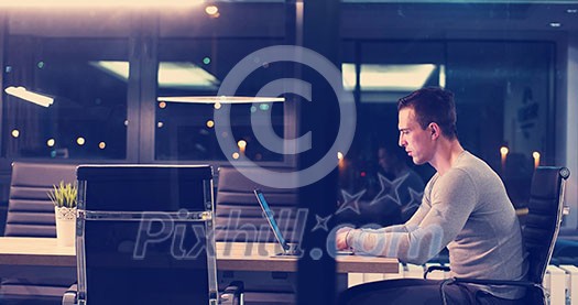 Young man working on laptop at night in dark office. The designer works in the later time. Young man working on laptop at night in dark office. The designer works in the later time.