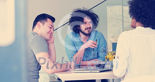 Multiethnic startup business team on meeting in modern bright office interior brainstorming, working on laptop and tablet computer Multiethnic startup business team on meeting in modern bright office interior brainstorming, working on laptop and tablet computer