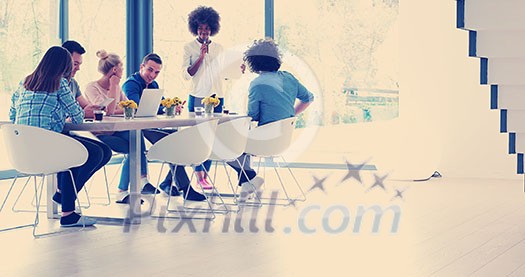Multiethnic startup business team on meeting in modern bright office interior brainstorming, working on laptop and tablet computer Multiethnic startup business team on meeting in modern bright office interior brainstorming, working on laptop and tablet computer