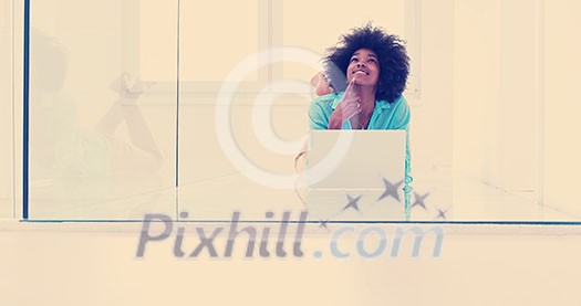 beautiful young african american women using laptop computer on the floor of her luxury home beautiful young african american women using laptop computer on the floor of her luxury home