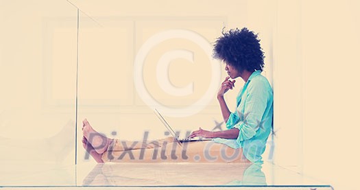 beautiful young african american women using laptop computer on the floor of her luxury home beautiful young african american women using laptop computer on the floor of her luxury home
