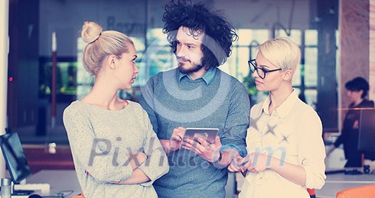 Group of a young business people discussing business plan at modern startup office building Group of a young business people discussing business plan at modern startup office building