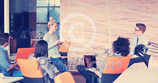 Group of a young business people discussing business plan at modern startup office building Group of a young business people discussing business plan at modern startup office building