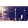 Young man working on computer at night in dark office. The designer works in the later time.