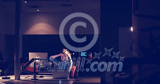 A time for relax. Young tired casual businessman relaxing at the desk in his night office A time for relax. Young tired casual businessman relaxing at the desk in his night office