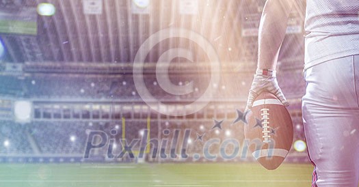 Closeup Portrait of a strong muscular American Football Player on big modern stadium field with lights and flares Closeup Portrait of a strong muscular American Football Player on big modern stadium field with lights and flares