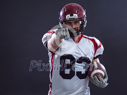 Portrait of American football player pointing against gray background Portrait of American football player pointing against gray background
