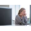 Pretty, female student looking at a desktop computer screen, learning unpleasant news about her exam results. University/office/school concept