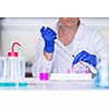 Hands of a female researcher carrying out research in a chemistry lab (color toned image; shallow DOF)