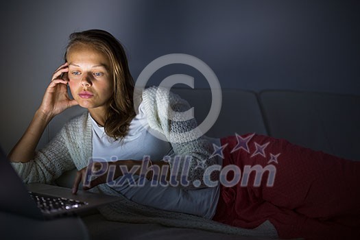 Very tired young woman, burning the midnigh oil - working late at night on her laptop computer, at home, sitting on sofa, rubbing her tired eyes, trying to stay focused Very tired young woman, burning the midnigh oil - working late at night on her laptop computer, at home, sitting on sofa, rubbing her tired eyes, trying to stay focused