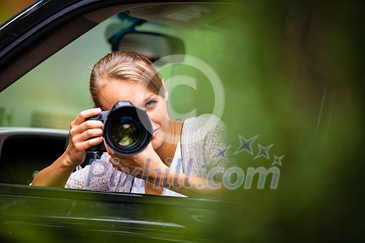 Female photographer/paparazzi taking pictures of a famous high-profile person from her car Female photographer/paparazzi taking pictures of a famous high-profile person from her car