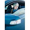 Woman driving a car - female driver at a wheel of a modern car, looking happy, smiling with a relaxed smile (shallow DOF; color toned image)