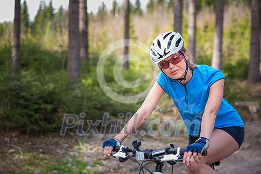 Pretty, young female biker outdoors on her mountain bike (shallow DOF; selective focus) Pretty, young female biker outdoors on her mountain bike (shallow DOF; selective focus)