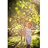 Pretty, young woman gardening in her garden, cutting branches, taking care of her lovely orchard