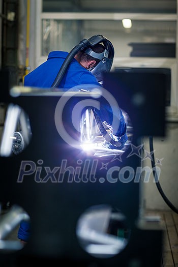 Industrial workers welding metal with many sharp sparks, Welder working a welding metal with protective mask and sparks Industrial workers welding metal with many sharp sparks, Welder working a welding metal with protective mask and sparks