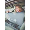 Pretty young woman driving her new car
