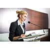 Pretty, young business woman giving a presentation in a conference/meeting setting (shallow DOF; color toned image)